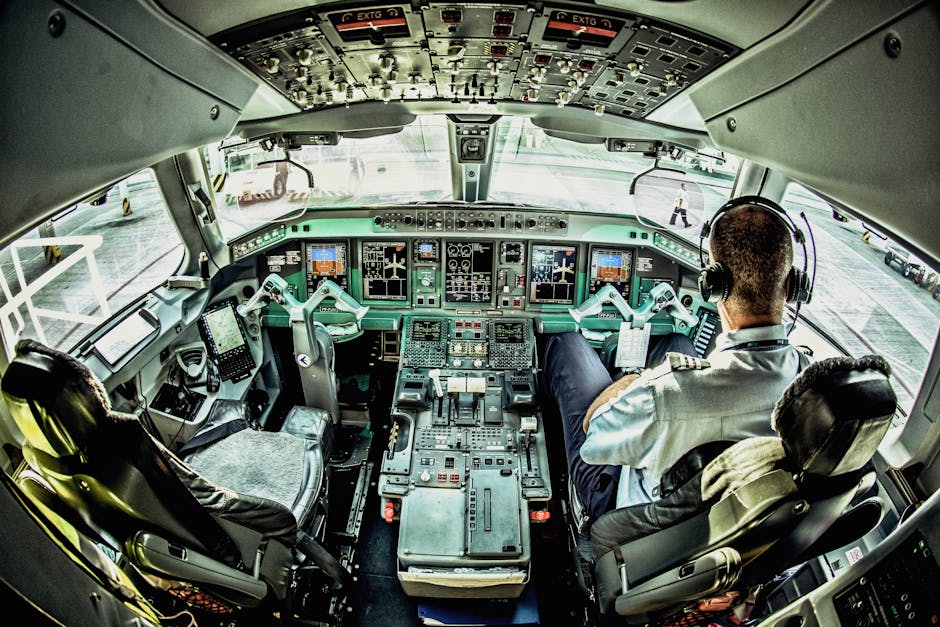 View of an airplane cockpit with a pilot actively managing the controls.